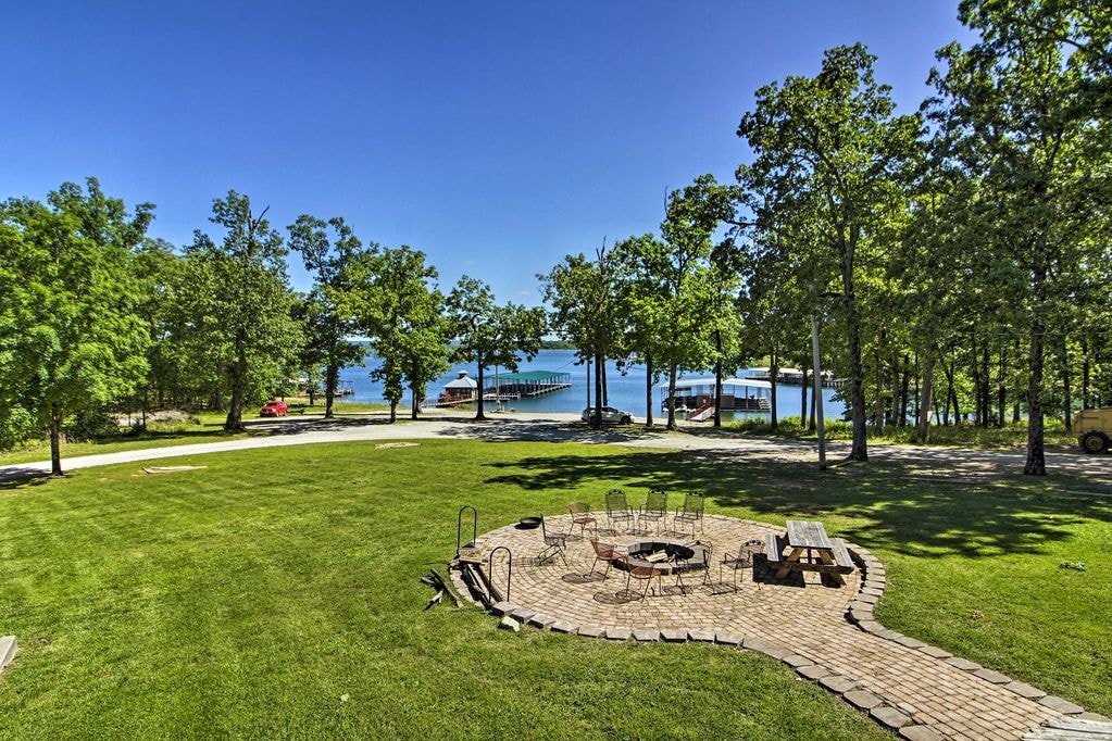 Lakeside fire pit gathering area with lake and dock views