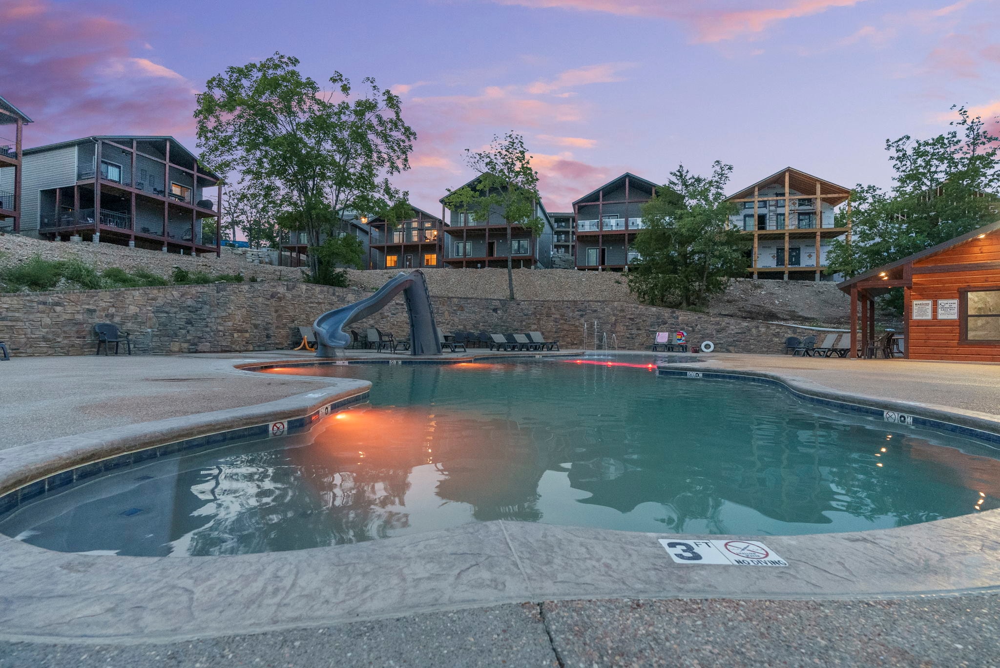 Saltwater pool with waterslide at dusk
